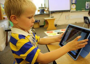 A boy uses an ipad in the classroom